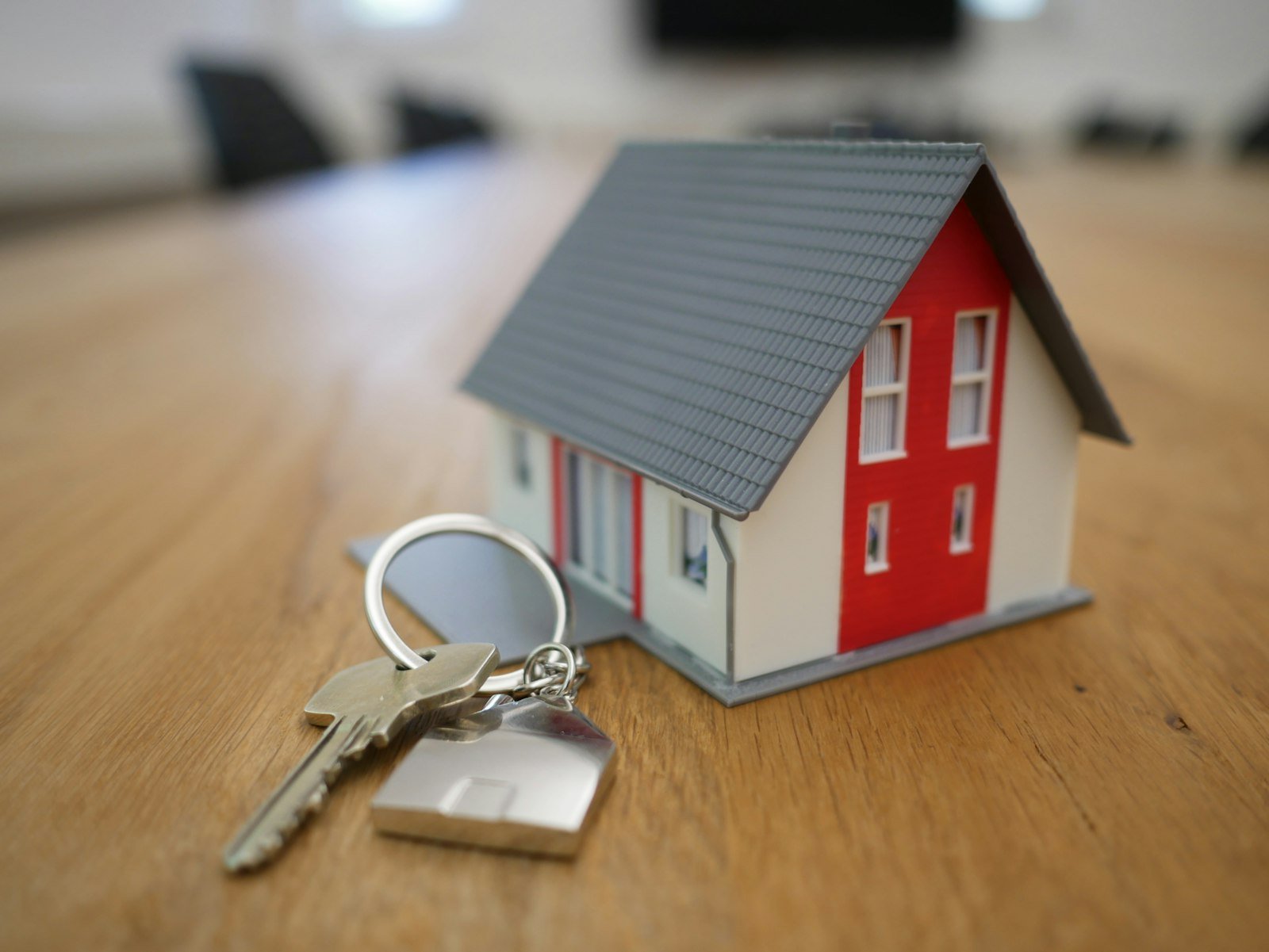 Llaves y maqueta de casa sobre escritorio, documentos para vender una casa en Córdoba